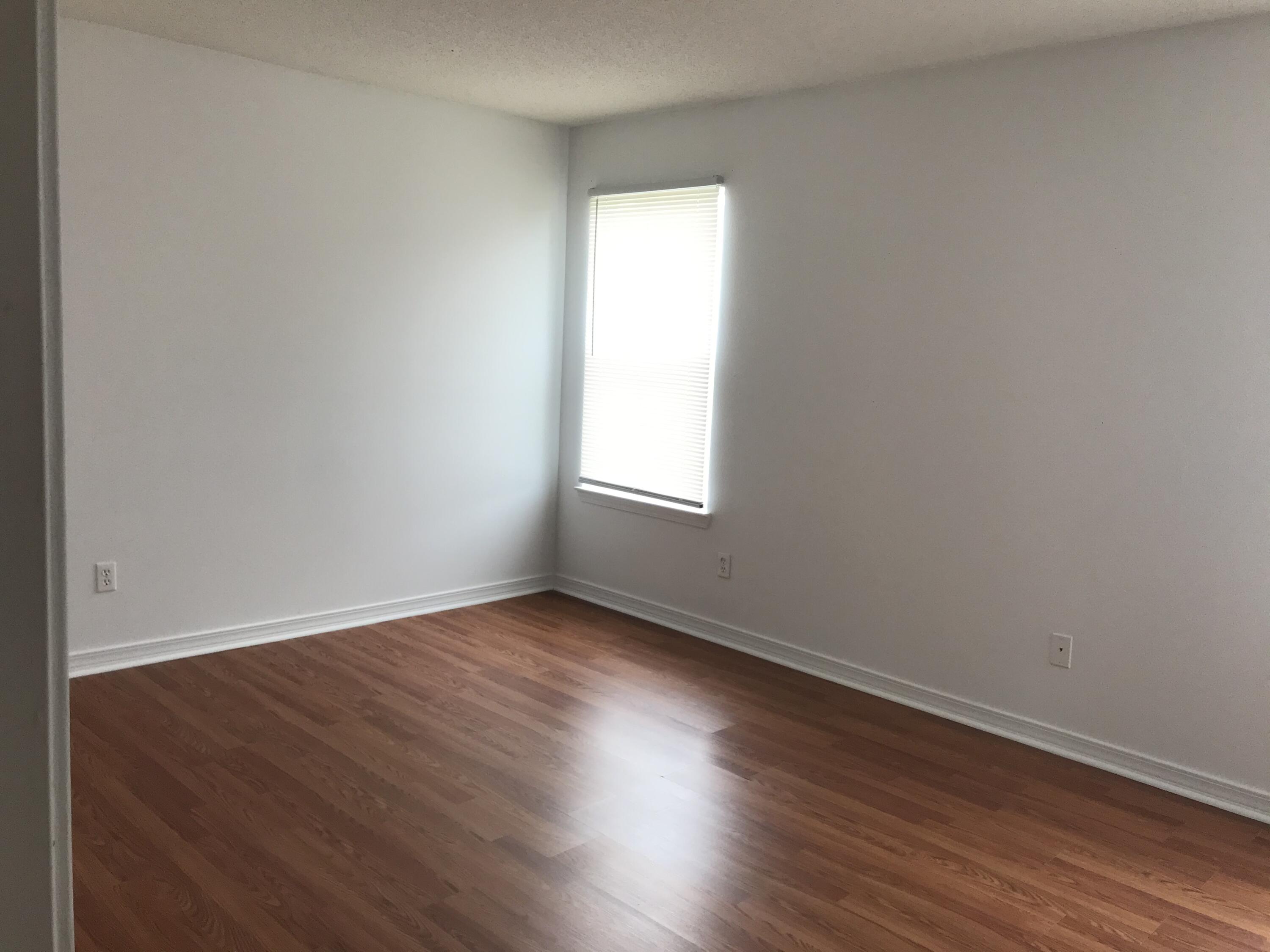 294 Limestone Circle Crestview, FL 32539 - Photo 12 of 19 an empty room with wooden floor and windows