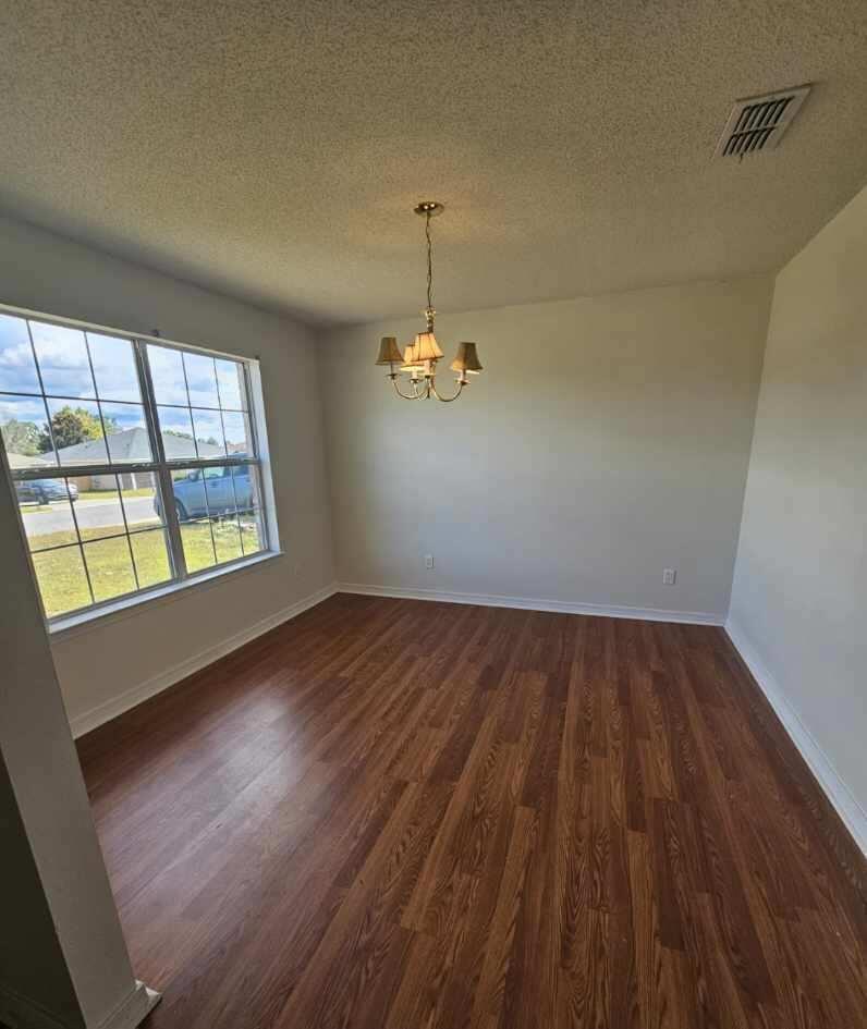 294 Limestone Circle Crestview, FL 32539 - Photo 7 of 19 wooden floor in an empty room with a window