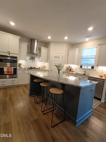 a kitchen with stainless steel appliances granite countertop wooden cabinets a stove a sink and a refrigerator