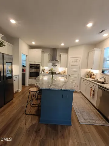 a kitchen with stainless steel appliances wooden floors and wooden cabinets