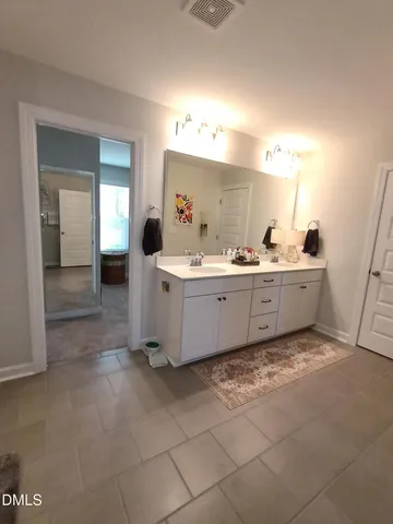 a bathroom with a double vanity sink and a mirror