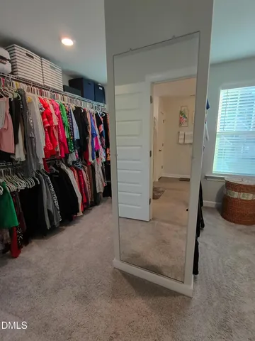 a view of walk in closet with clothes
