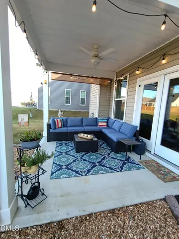 a view of a patio with table and chairs barbeque potted plants and large tree