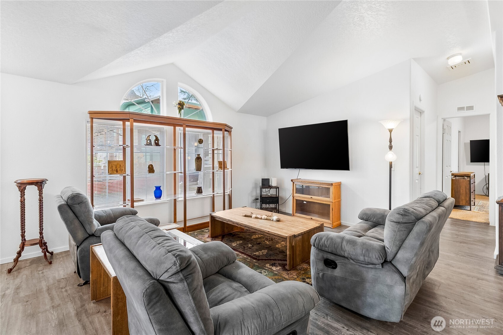 1200 Lincoln Street, Unit 193 Bellingham, WA 98229 - Photo 5 of 18 a living room with furniture a flat screen tv and a floor to ceiling window