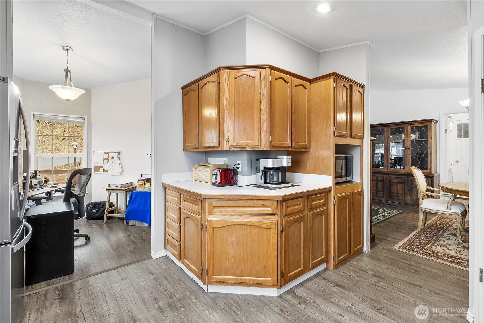 1200 Lincoln Street, Unit 193 Bellingham, WA 98229 - Photo 9 of 18 a kitchen with stainless steel appliances granite countertop a stove a sink dishwasher and a dining table with wooden floor