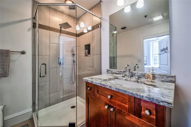 a bathroom with a granite countertop sink mirror and shower