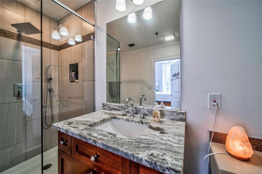 57 Forsyth Street Northwest, Unit 12B Atlanta, GA 30303 - Photo 23 of 38 a bathroom with a granite countertop sink a mirror and shower