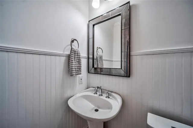 a bathroom with a sink a toilet and mirror