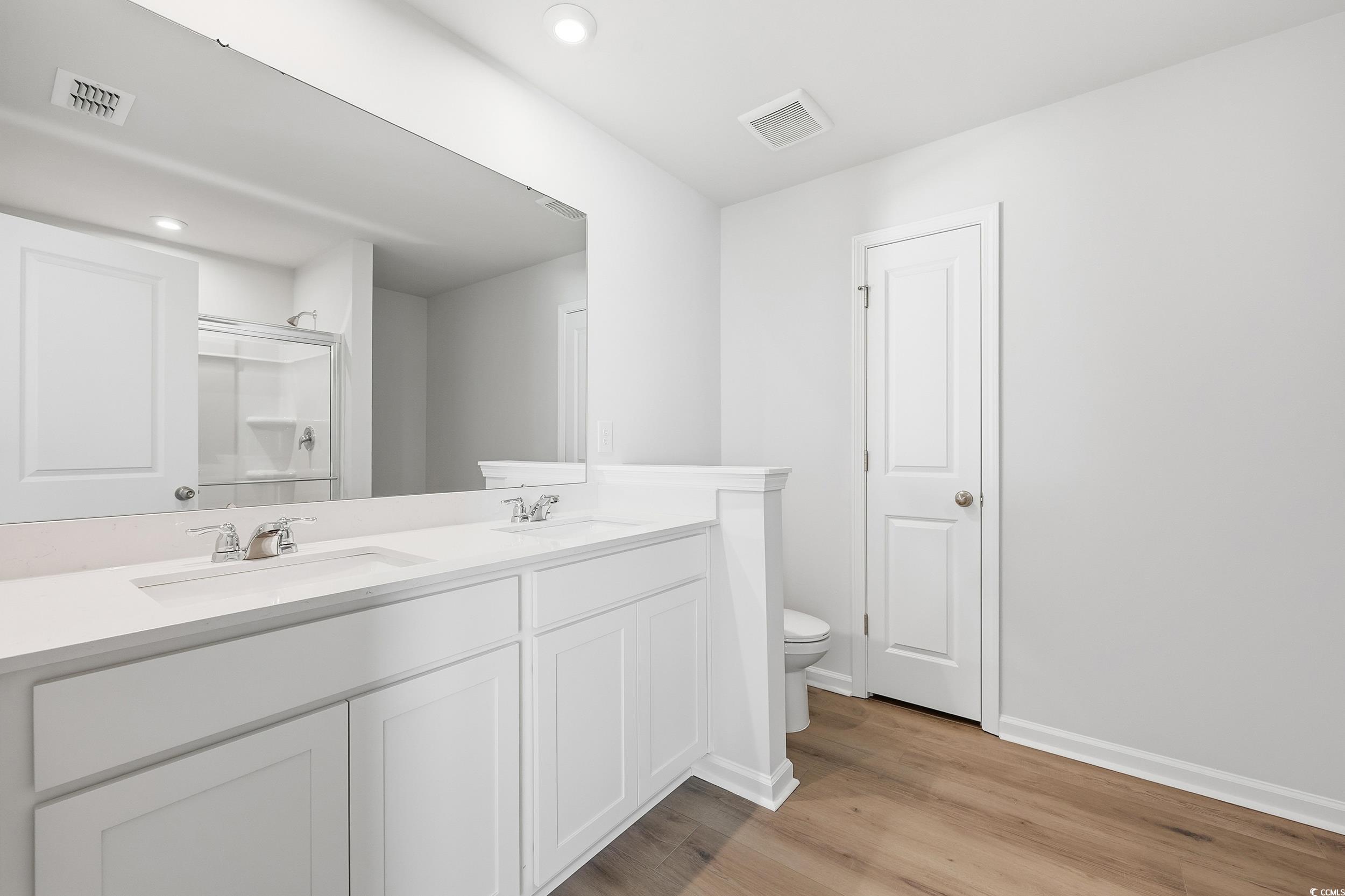 3055 Visionary Drive Myrtle Beach, SC 29588 - Photo 27 of 31 Bathroom featuring a shower stall, double vanity, light wood-type flooring, and recessed lighting