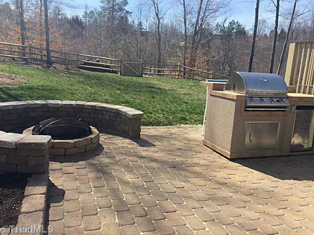 5083 Peppertree Road Clemmons, NC 27012 - Photo 16 of 16 Exterior Back. Fenced rear yard with large deck AND stone paver patio, firepit, grilling station with fridge