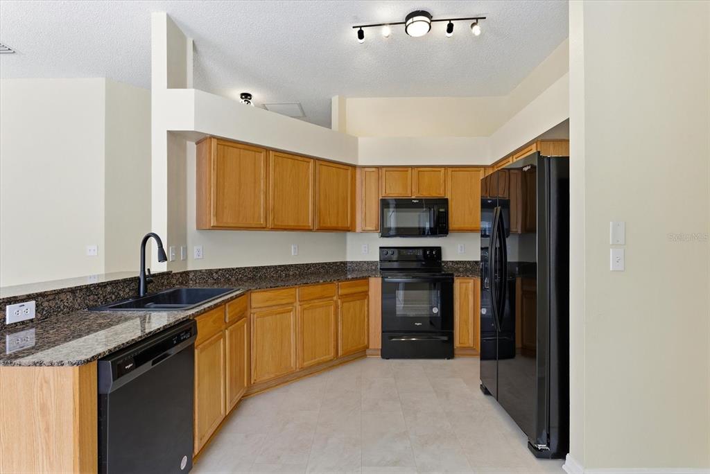 12923 Fieldmoor Court Riverview, FL 33579 - Photo 15 of 37 a kitchen with stainless steel appliances granite countertop a refrigerator and a sink