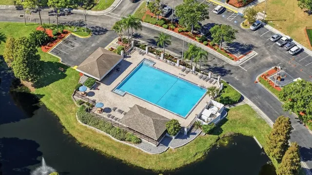 an aerial view of a house with swimming pool and large trees