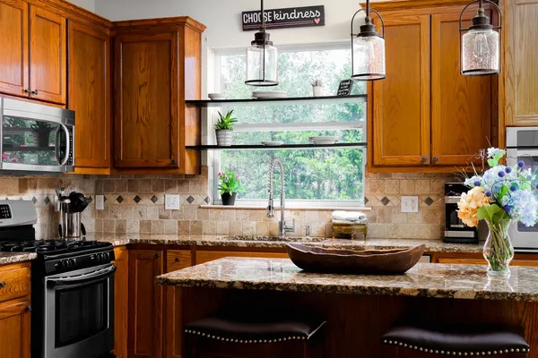 a kitchen with a stove a sink and a wooden cabinets