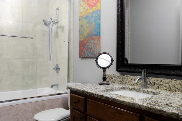 a bathroom with a granite countertop sink toilet and shower