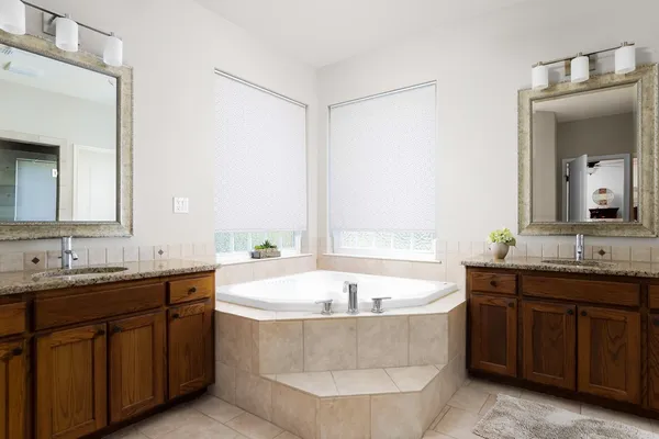a bathroom with a tub sink and mirror