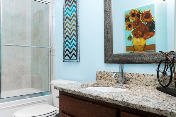a bathroom with a granite countertop sink and a mirror