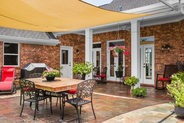 a view of a patio with table and chairs potted plants