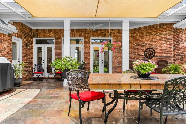 a view of a house with a table and chairs in patio