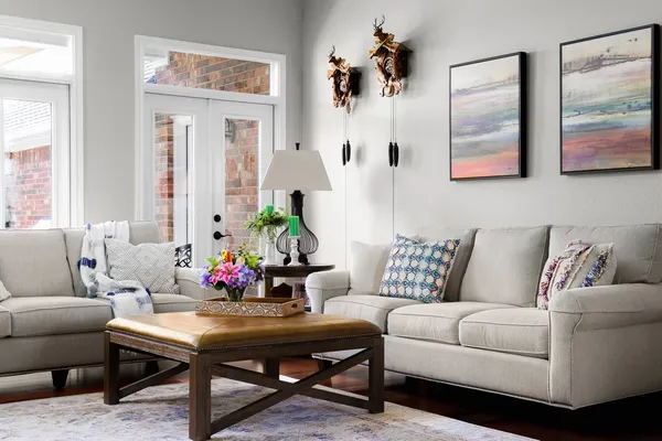 a living room with furniture and paintings on the wall