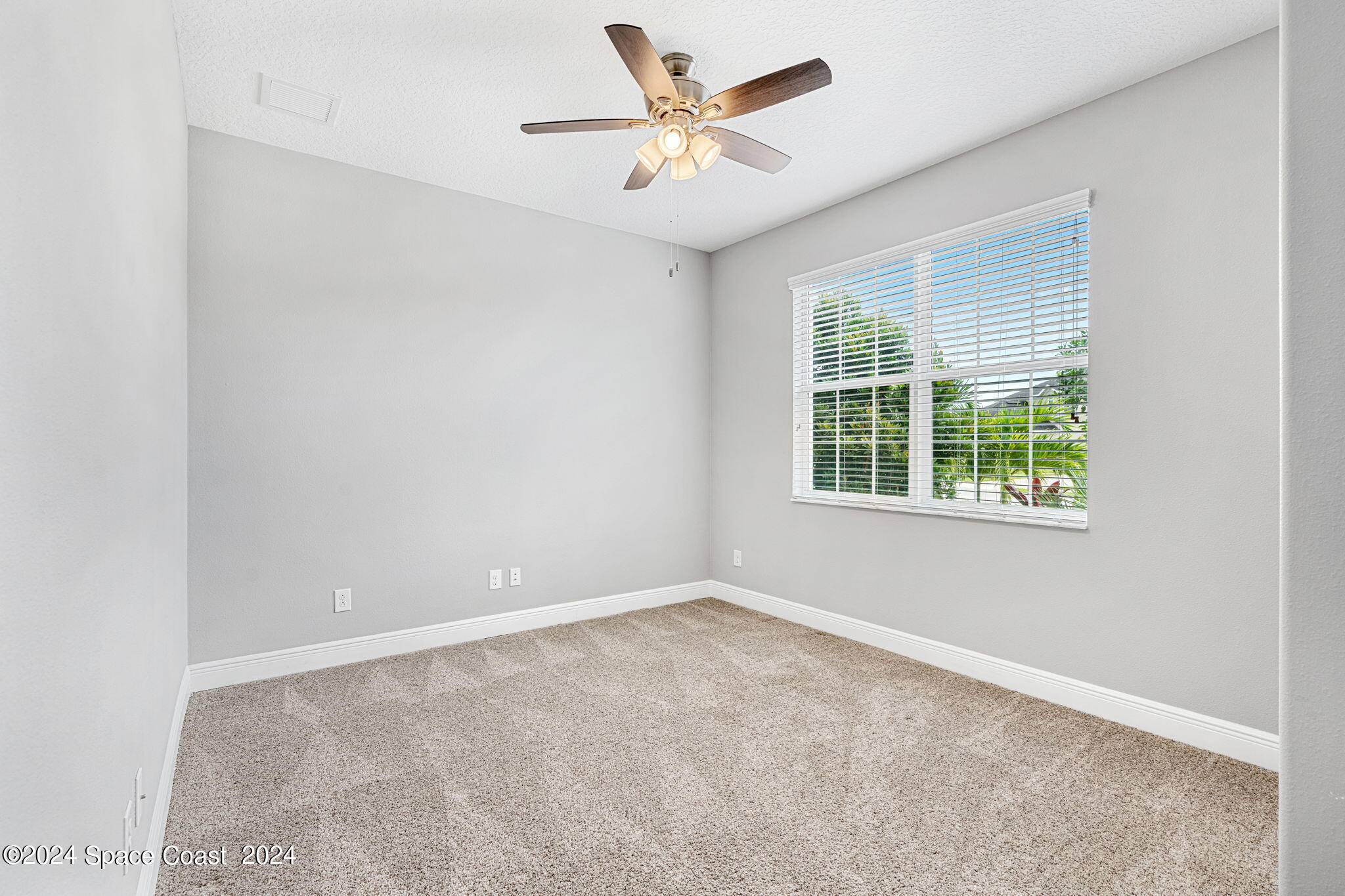 3034 Casterton Drive Melbourne, FL 32940 - Photo 18 of 38 an empty room with a window and a fan