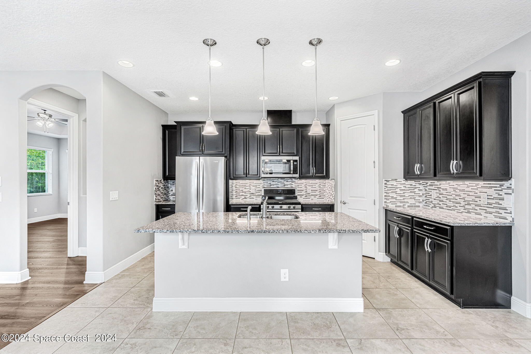 3034 Casterton Drive Melbourne, FL 32940 - Photo 7 of 38 a kitchen with kitchen island a counter top space a sink stainless steel appliances and cabinets