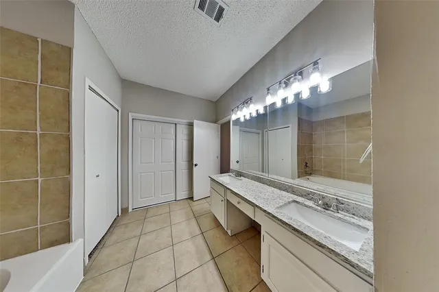 a spacious bathroom with a granite countertop sink a mirror and a shower