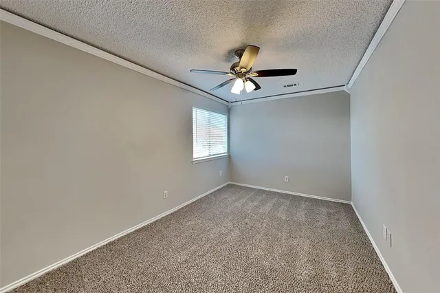 an empty room with windows and ceiling fan