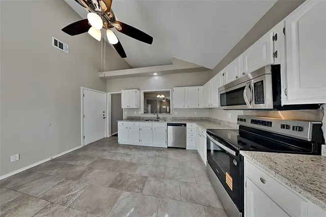 a kitchen with stainless steel appliances a sink stove and microwave
