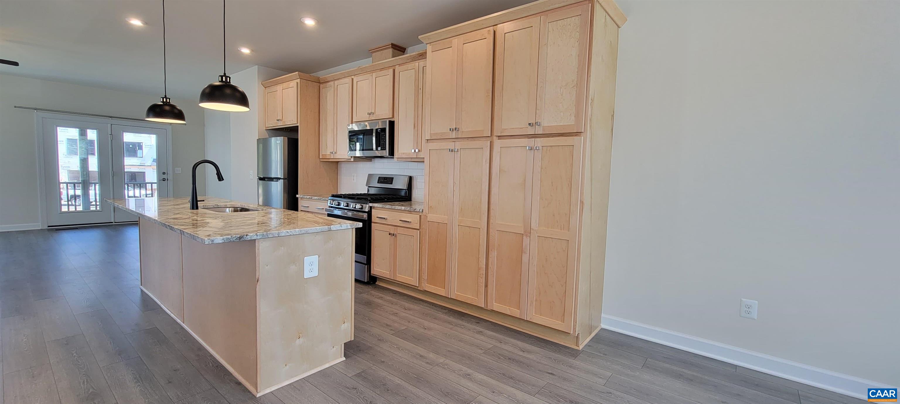 2245 Fowler Street Charlottesville, VA 22901 - Photo 12 of 38 a kitchen with kitchen island granite countertop wooden floors and white cabinets