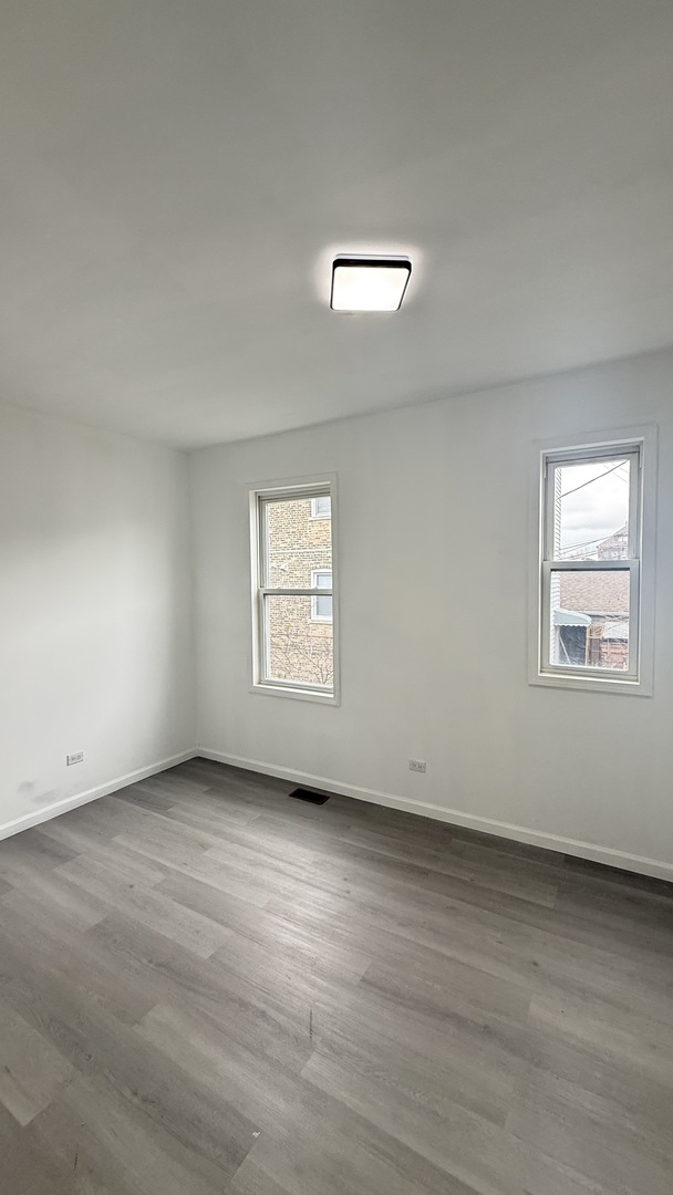 2942 West Pershing Road Chicago, IL 60632 - Photo 6 of 16 an empty room with wooden floor and windows