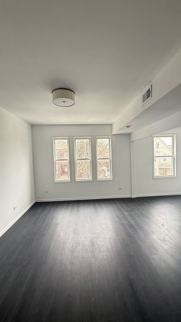 2942 West Pershing Road Chicago, IL 60632 - Photo 7 of 16 a view of a livingroom with wooden floor and window