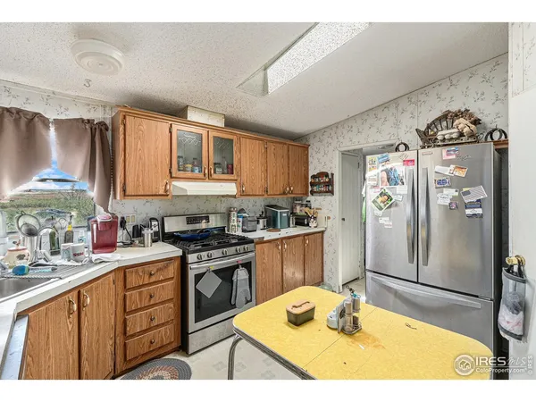 a kitchen with stainless steel appliances granite countertop a sink refrigerator and cabinets