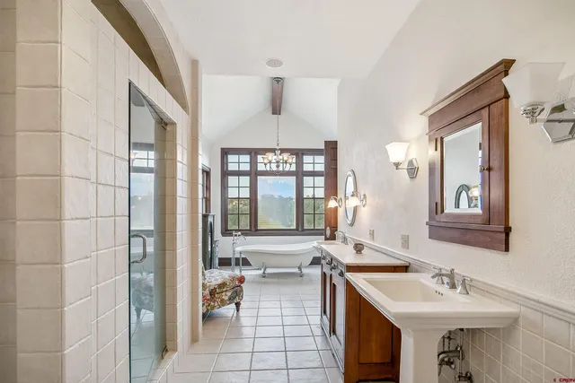 a spacious bathroom with a double vanity sink a mirror and a bathtub