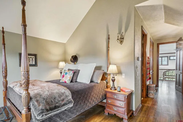 a bedroom with bed and wooden floor