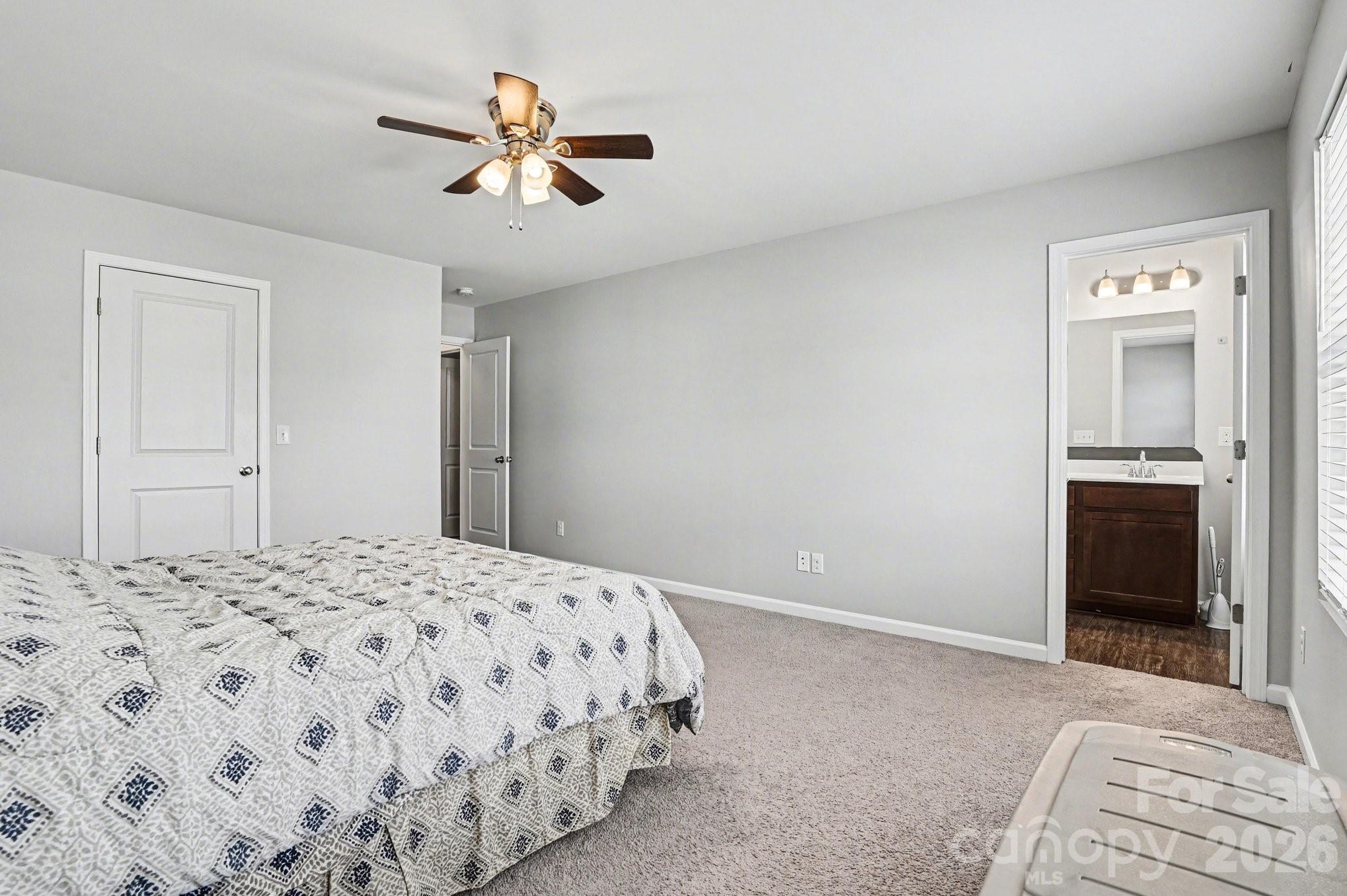 12527 Gotland Road Midland, NC 28107 - Photo 18 of 24 a bedroom with a bed and a chandelier