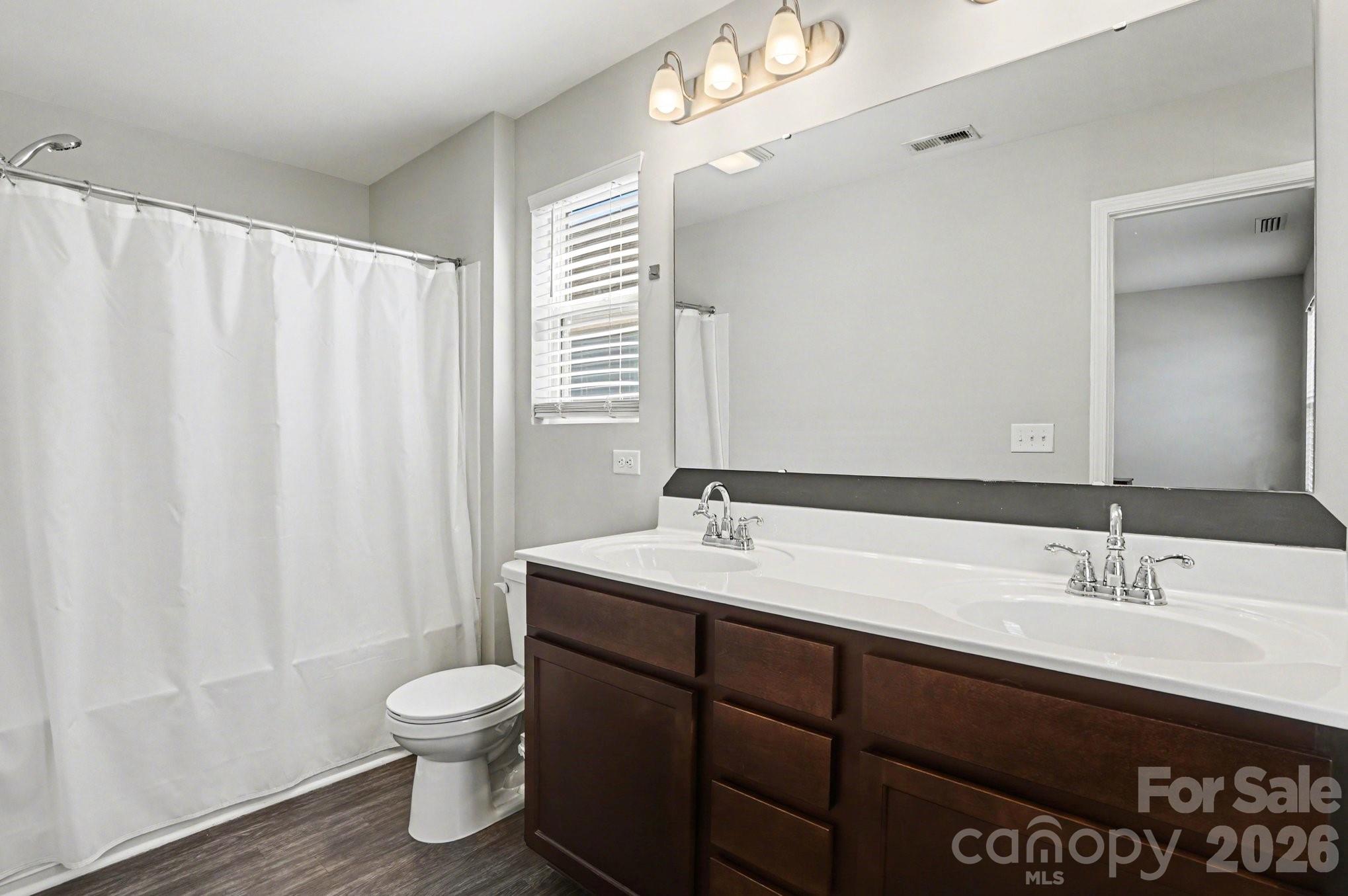 12527 Gotland Road Midland, NC 28107 - Photo 19 of 24 a bathroom with a double vanity sink toilet and a mirror