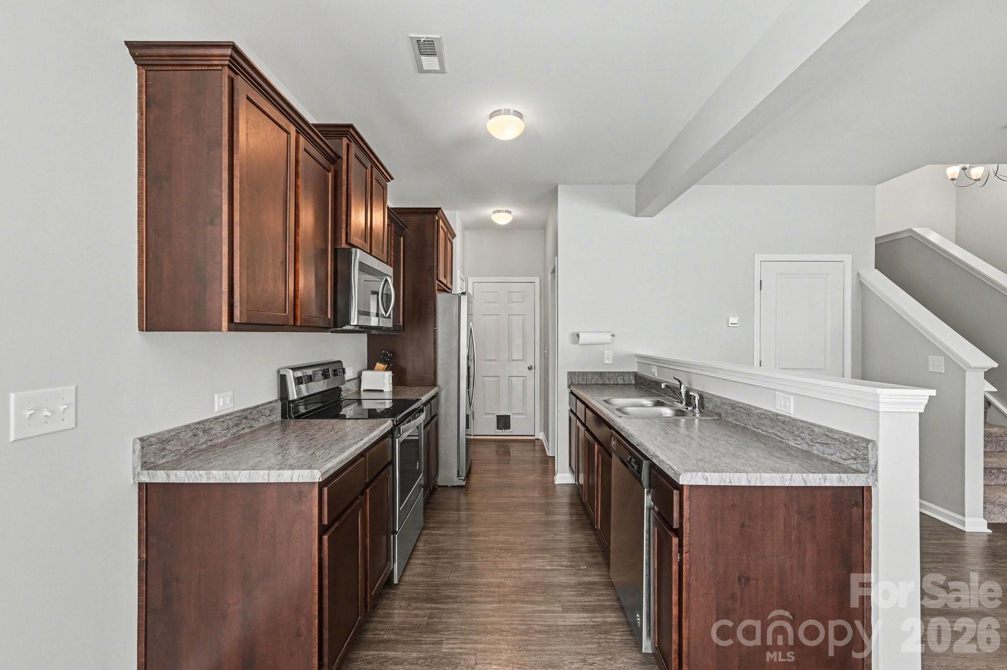 12527 Gotland Road Midland, NC 28107 - Photo 7 of 24 a kitchen with stainless steel appliances granite countertop a sink stove and refrigerator