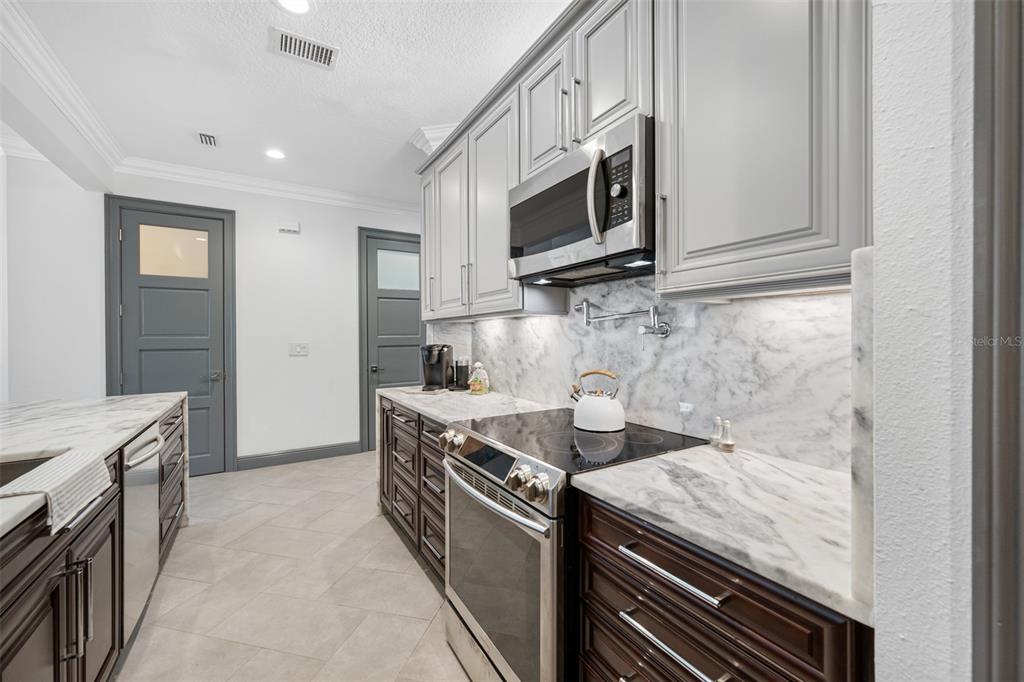 237 7th Avenue North, Unit 2 St. Petersburg, FL 33701 - Photo 11 of 60 a kitchen with stainless steel appliances granite countertop a stove and a microwave