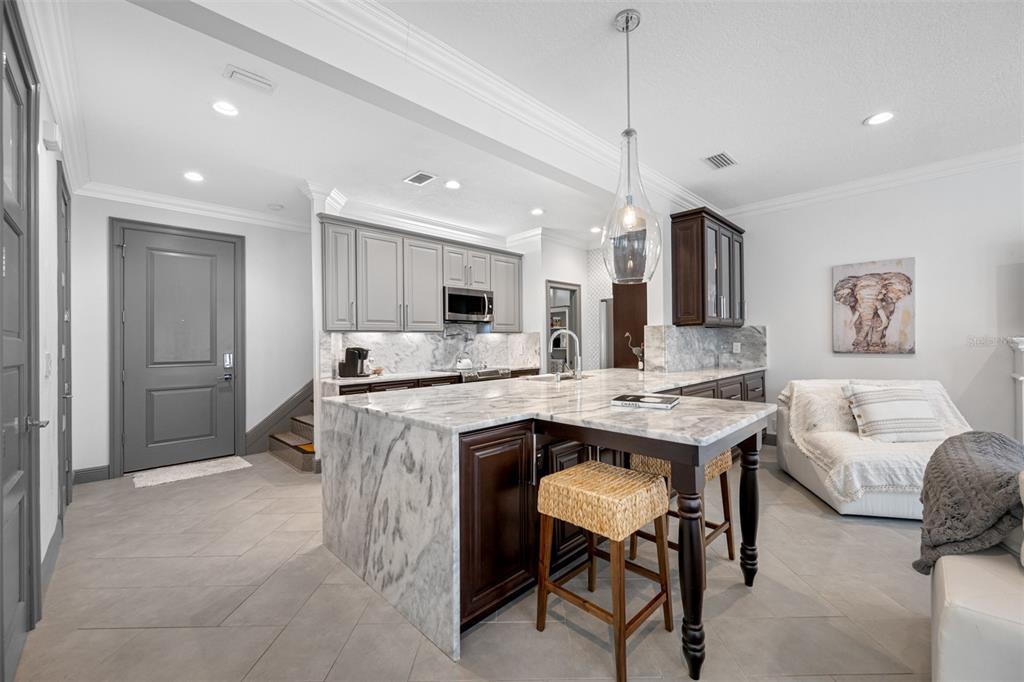 237 7th Avenue North, Unit 2 St. Petersburg, FL 33701 - Photo 12 of 60 a living room with kitchen island furniture and a kitchen view