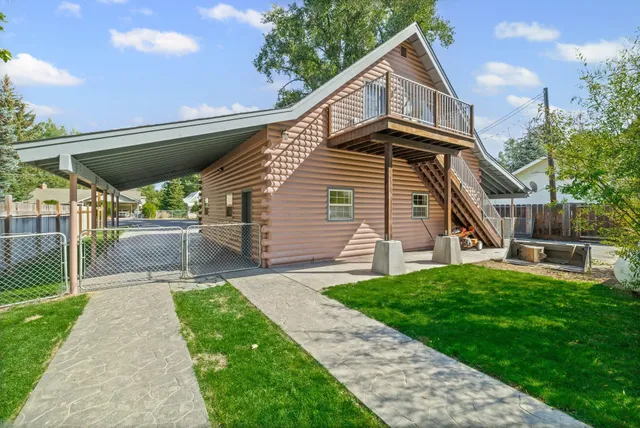 a view of a house with a yard patio and wooden fence