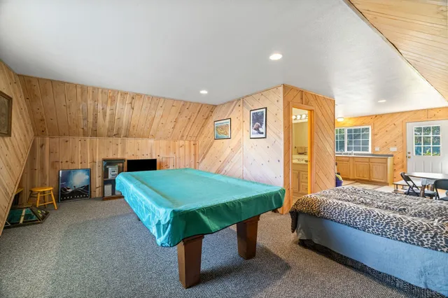 a backyard of a house with large trees and plants