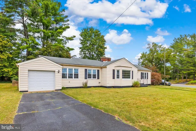 a front view of a house with yard and green space
