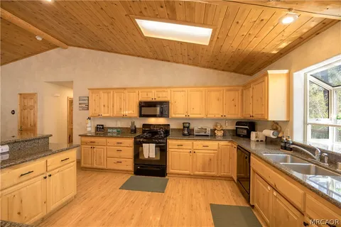 a large kitchen with stainless steel appliances granite countertop a stove sink and cabinets