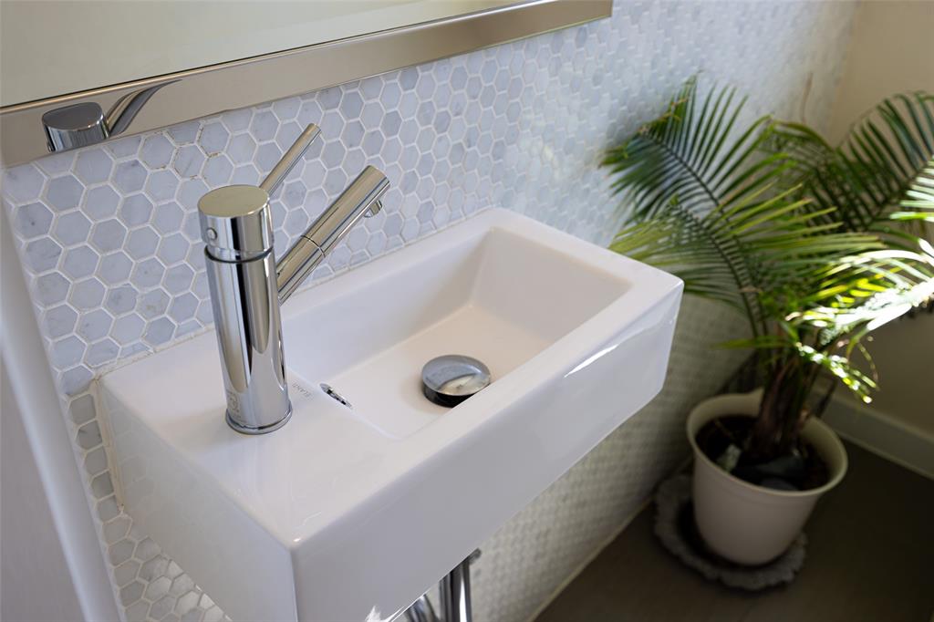3922 Gilbert Avenue, Unit 214 Dallas, TX 75219 - Photo 20 of 27 Wall-mounted rectangular sink with chrome single-handle faucet, set against a hexagonal tile backsplash