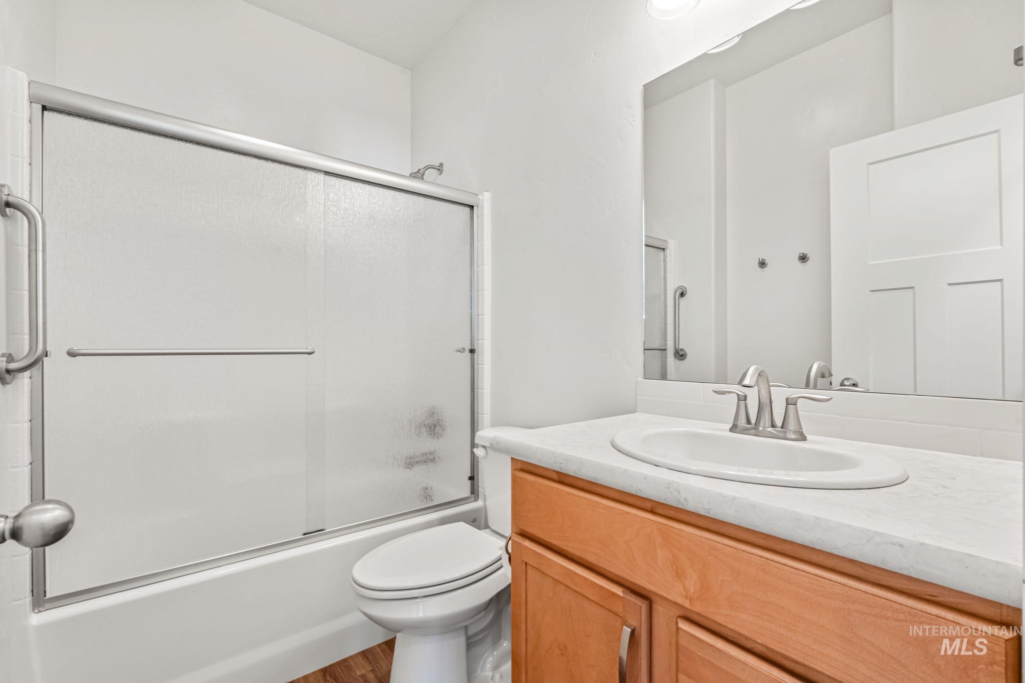 395 Cutlass Payette, ID 83661 - Photo 13 of 26 Bathroom featuring bath / shower combo with glass door, vanity, and wood finished floors