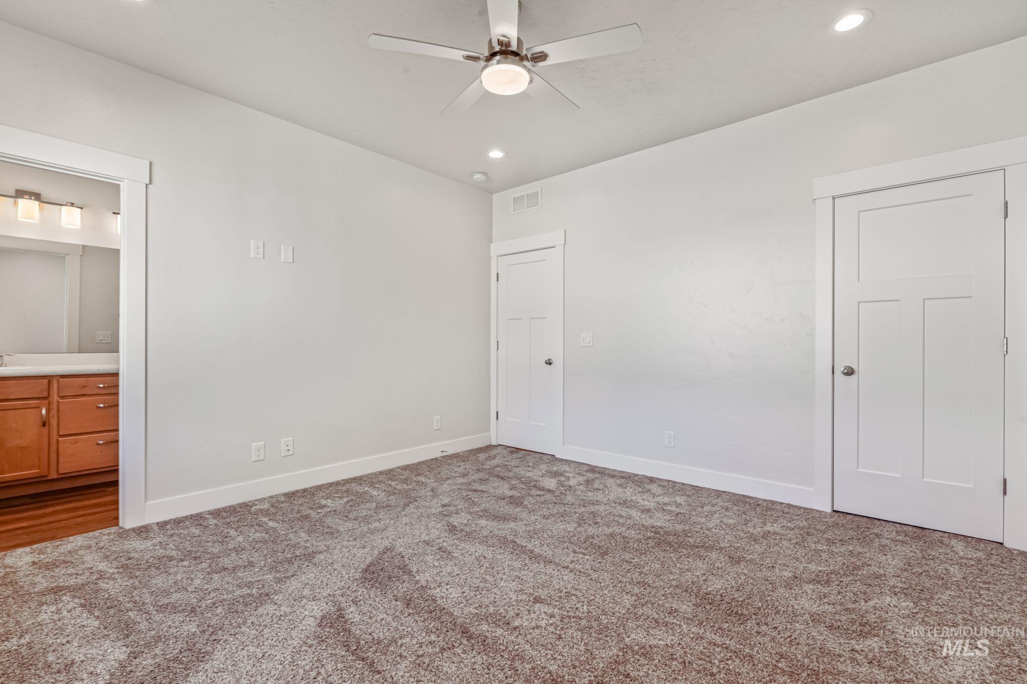 395 Cutlass Payette, ID 83661 - Photo 14 of 26 Unfurnished bedroom featuring ensuite bath, recessed lighting, carpet flooring, and ceiling fan