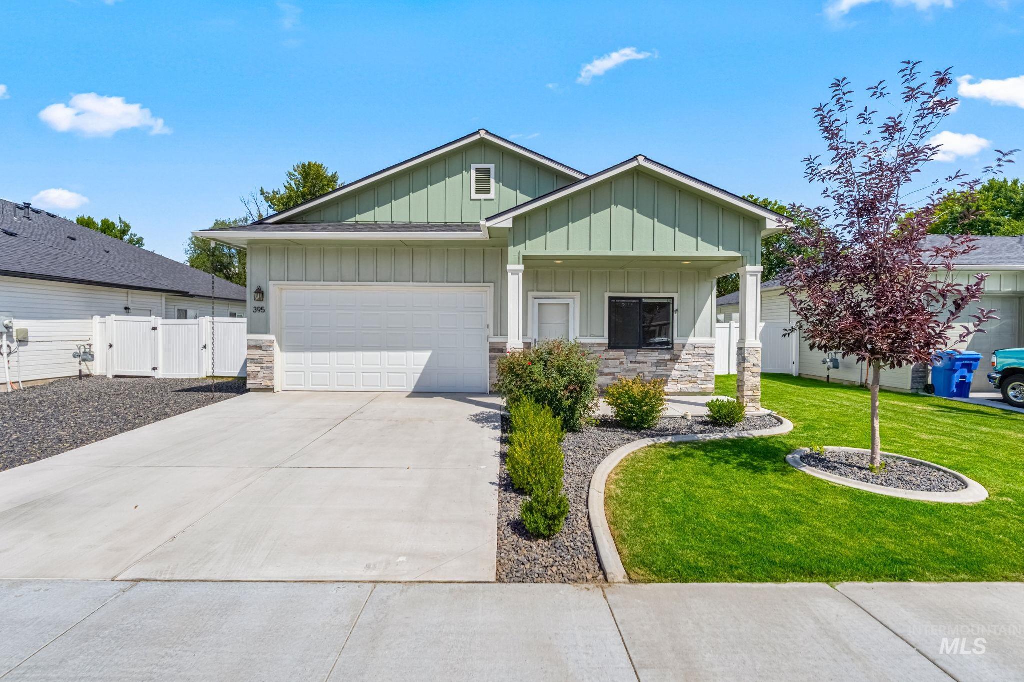 395 Cutlass Payette, ID 83661 - Photo 2 of 26 View of front of house with board and batten siding, a gate, stone siding, a garage, and driveway