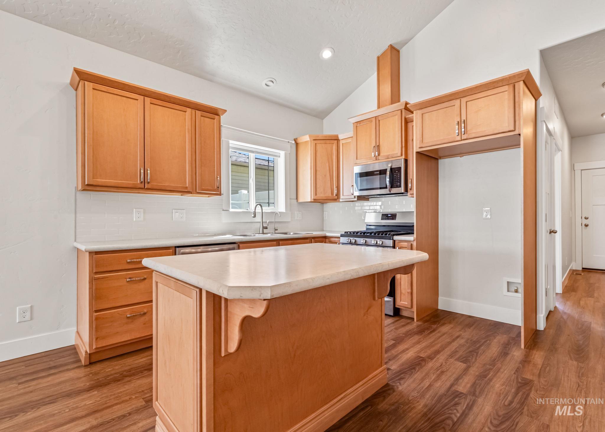 395 Cutlass Payette, ID 83661 - Photo 6 of 26 Kitchen featuring tasteful backsplash, lofted ceiling, light countertops, light wood-type flooring, and recessed lighting
