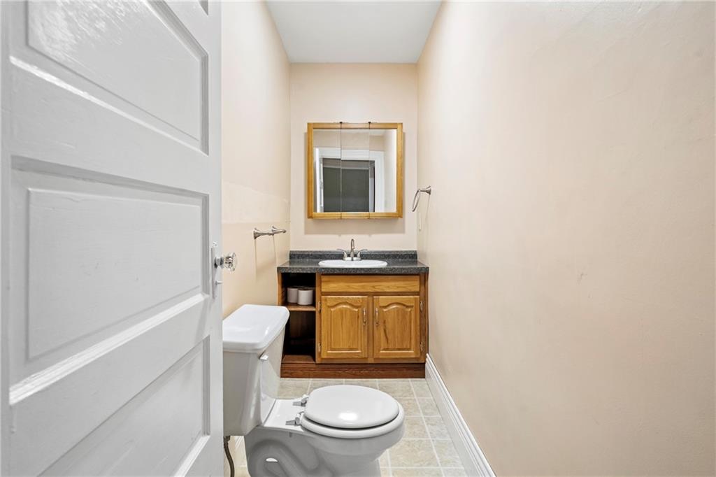 2725 Sumner Street Pittsburgh, PA 15203 - Photo 14 of 37 a bathroom with a granite countertop toilet sink and mirror