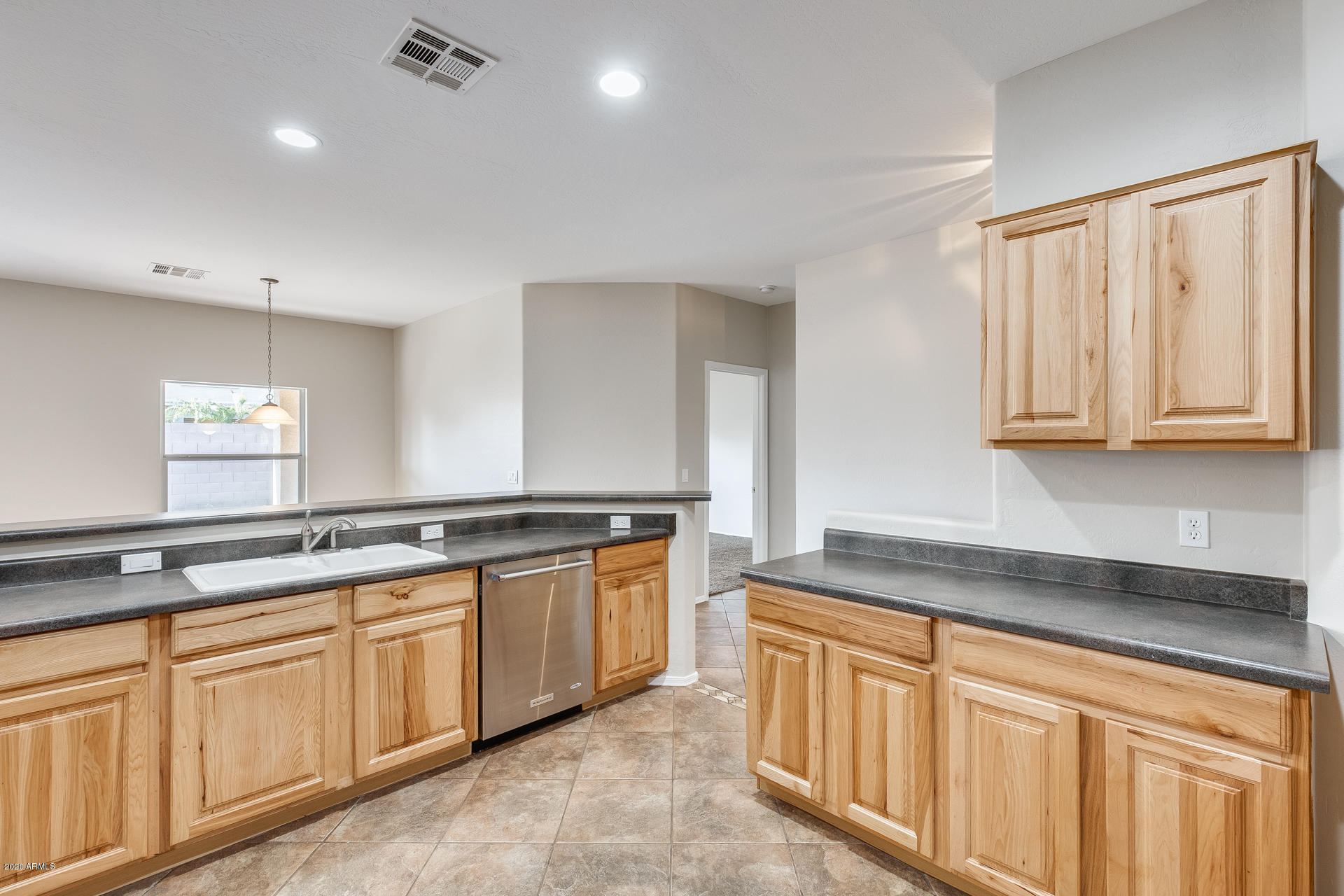 15644 West Calavar Road Surprise, AZ 85379 - Photo 12 of 34 a kitchen with stainless steel appliances granite countertop a sink and cabinets with wooden floor